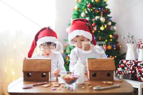 Two sweet boys, brothers, making gingerbread cookies house Stock Photos