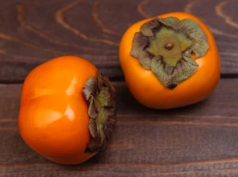 Two sweet persimmons Stock Photos