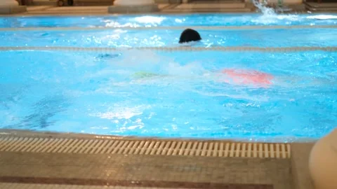 Two swimmers doing breaststroke toward each other in pool on parallel lanes Vídeos de archivo 333200676