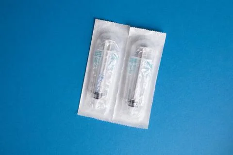 Two syringes on a blue background in a package. Stock Photos