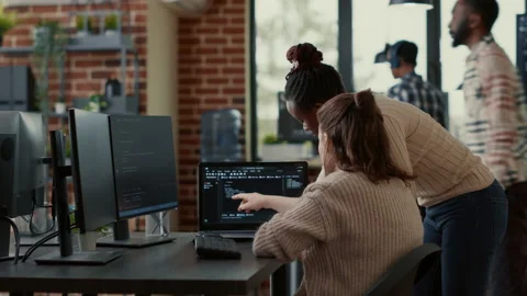 Two system engineers analyzing source code on laptop looking for errors on Stock Footage 168241111