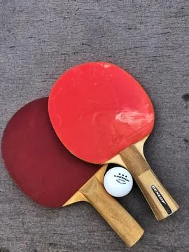 Two table tennis or ping pong rackets and balls on a blue table Stock Photos