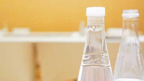 Two tables, water bottle, two glasses, white tablecloth, black box. Stock Photos