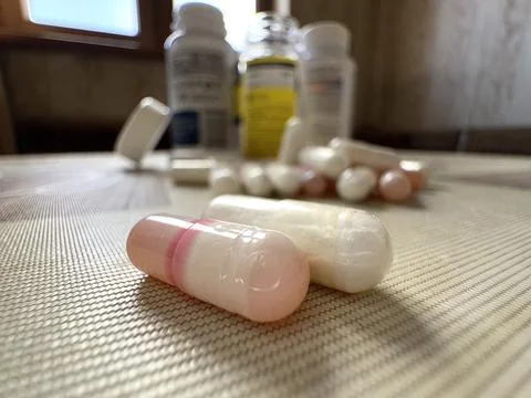 Two tablets in capsules are lying on the table from a close distance, and in the Stock Photos