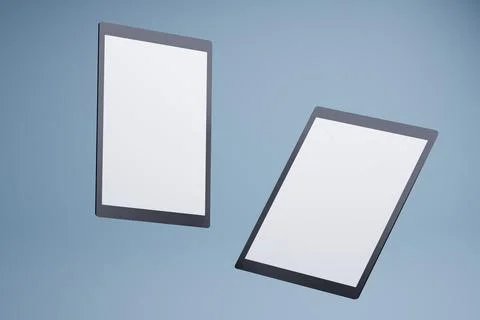 Two tablets floating, blank screens, blue background, mockup Illustrazione stock