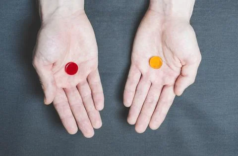 Two tablets red and yellow in different hands, choice Stock Photos