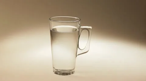 Two tablets of soluble vitamin C fall into a glass of water. Video stock 22256152