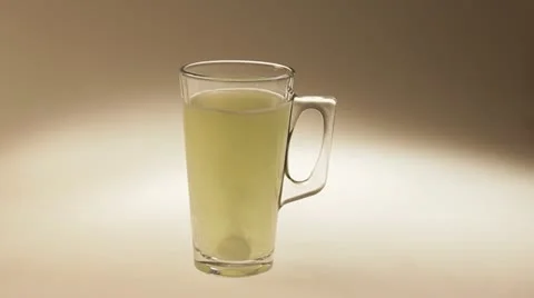 Two tablets of soluble vitamin C fall into a glass of water. Stock Footage 22256173