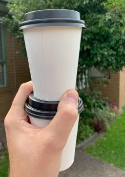 Two take away coffees held in one hand Stock Photos