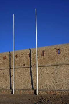 Two tall flagpoles without flags on a sandy beach Gravette, Antibes, Cote d'A Stock Photos