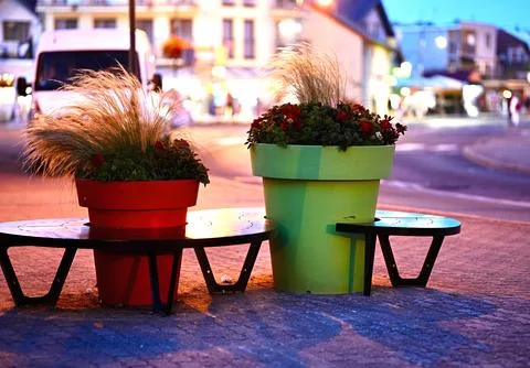 Two tall flower beds in the form of flower pots in a night city Stock Photos