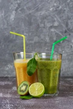 Two tall glasses of orange juice and a banana-orange kiwi and spinach smoothi Stock Photos