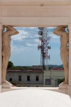 Two Tall stone Statue on Each Side of the Hall in front o houses and antenna Stock Photos