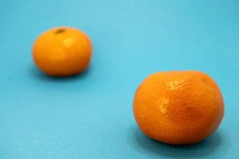 Two tangerines on a blue background. Stock Photos