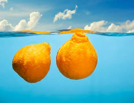 Two tangerines under water in the rays of the bright sun Stock Photos