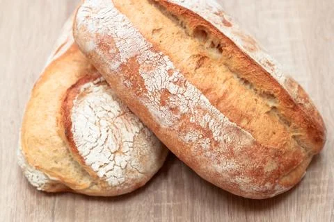 Two tasty baked bread on a light wooden background Stock Photos