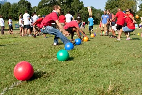 Two teams sprint for balls to begin dodge ball game Stock Photos