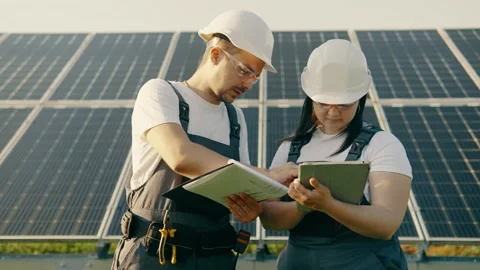 Two technical engineers discuss the result of an environmental solar power plant Video stock 255802002