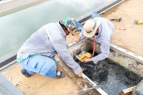 Two technician drill pit wall for install chemican anchor bolt. Stock-Fotos