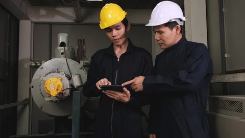 Two technician looking at tablet to analyzing problems of elevator. Stock Footage 129584650