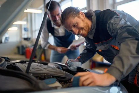 Two technicians doing car diagnostics together Stock Photos