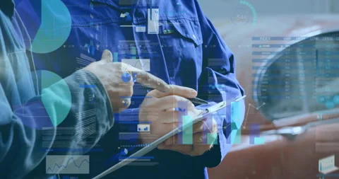 Two technicians examining engine data in automotive workshop, displaying Stock Footage 308115313