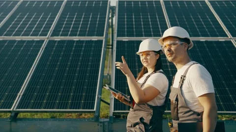 Two technicians lady and guy they walking through the solar panels rows. Stock Footage 255981484