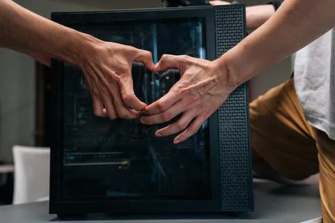 Two technicians making heart shape with hands in front of computer case Stock Photos