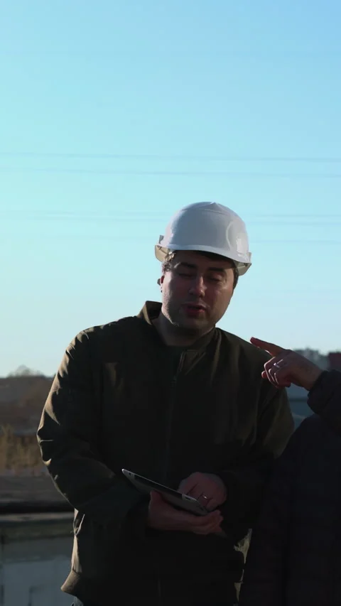 Two Technicians On Rooftop Planning Drone Flight Path While Checking Tablet Stock Footage 346990412