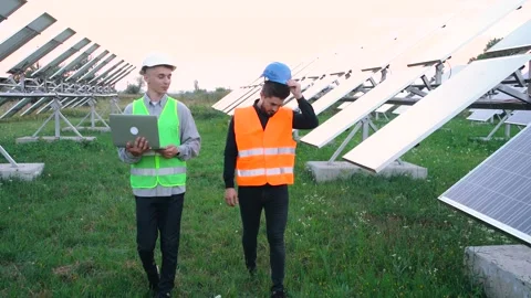 Two technicians walking through the field of solar panels. Stock Footage 140207225