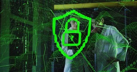 Two technicians wearing white coats studying green shield hologram over glass Illustrazione stock