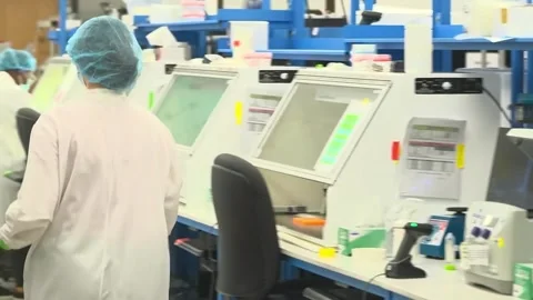 Two technicians work at a laboratory workstation at a crime laboratory testing Stock-Footage 345299166
