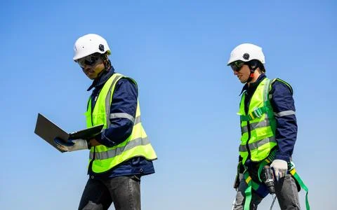Two technicians workers checking photovoltaic panels on solar farm Foto stock