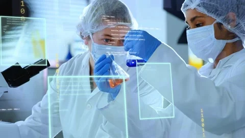 Two techs bringing orange and blue flasks at lab bench, checking clarity while Stock Footage 335235004