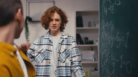 Two teen guys solving math task, giving each other high five, teamwork in school Stock Footage 250333936