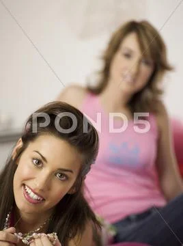 Two teenage girls (16-17) holding necklace, smiling Stock Photos