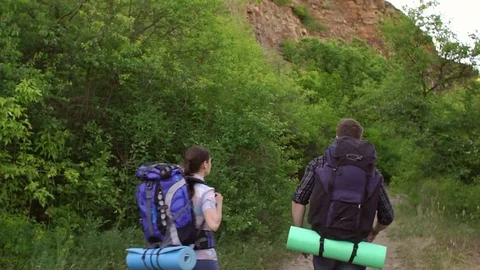 Two teenager traveling with backpacks in mountains Stock Footage