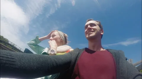 Two teenagers shouting while riding a coaster in the park Stock Footage 63996360