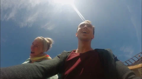 Two teenagers shouting while riding a coaster in the park Stock Footage 63997083