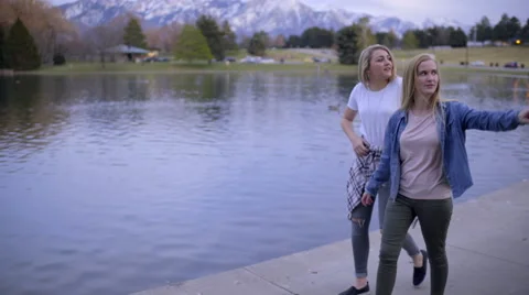 Two Teens Go For An Evening Walk Around Duck Pond In Park Stock-Footage 62632293