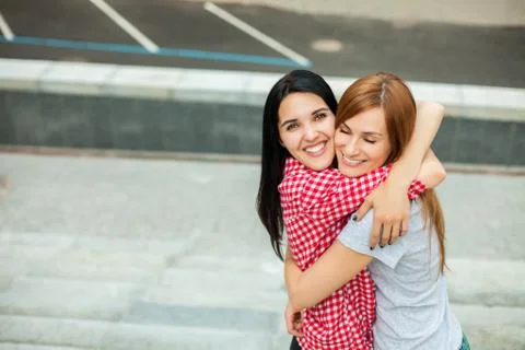 Two teens hugging in the street Stock Photos
