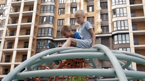 Two ten-year-old boys are sitting on a circular staircase in the playground. Stock Footage 288334746