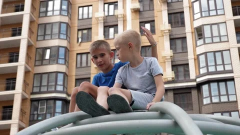 Two ten-year-old boys are sitting on a circular staircase in the playground. Stock Footage 331230408