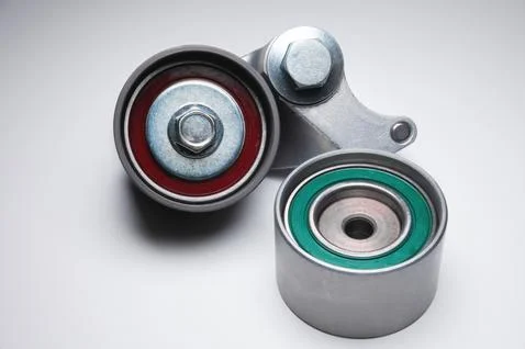 Two tensioning rollers of the engine timing belt on a gray background. New spare Fotos de archivo