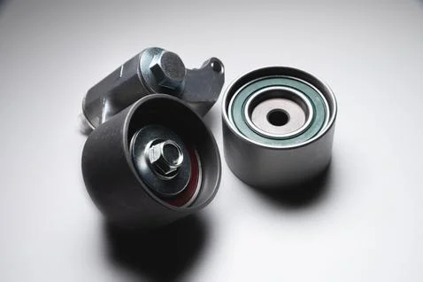 Two tensioning rollers of the engine timing belt on a gray background. New spare Stock Photos