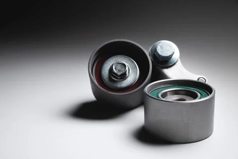 Two tensioning rollers of the engine timing belt on a gray background. New spare Fotos de archivo