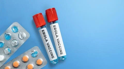 Two test tubes labeled Ebola Vaccine with blister packs of medication on a .. Stock Photos