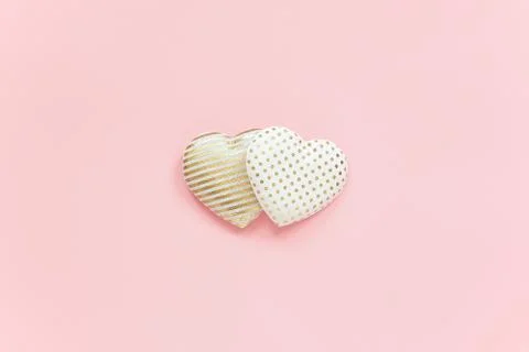 Two textile hearts with golden pattern on pink background, central compositio Stock Photos