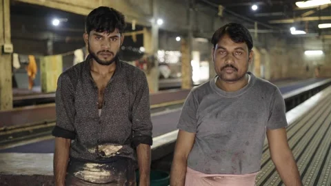 Two textile workers standing in a textile factory looking at the camera Stock Footage 149302271
