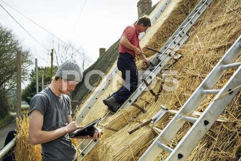 Two thatchers thatching a roof Stock Photos